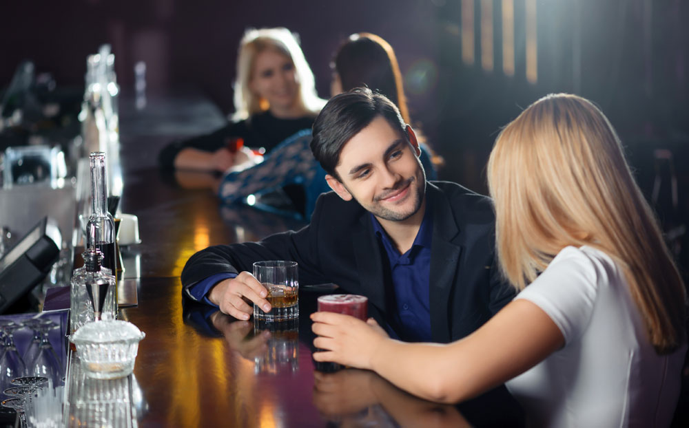 Man approaching a woman at a bar